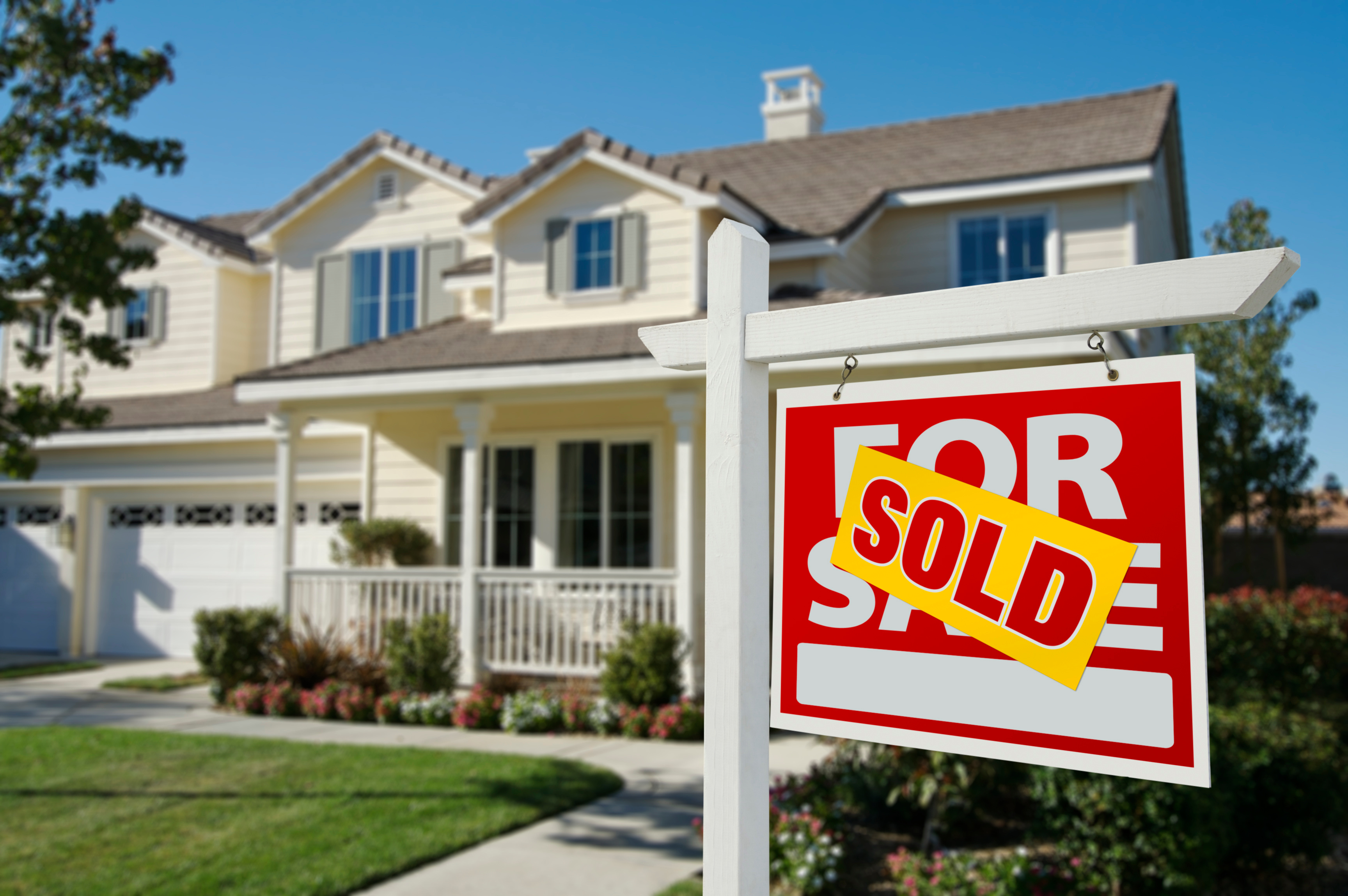 Home with a large SOLD sign in the front yard after a successful home purchase.